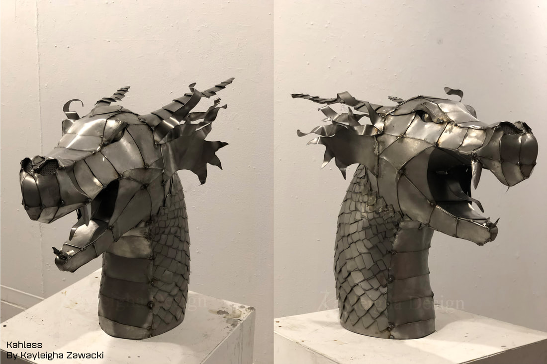 The neck and head of a 3D metal dragon with scales made from overlapping sheets of metal. She has a long tong and pointed fangs. Large fins stick out of the side of her face, and she has a long horn on either side of her head.